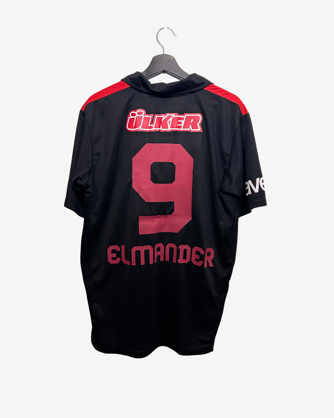 Black sports jersey with red accents and branding on a hanger
