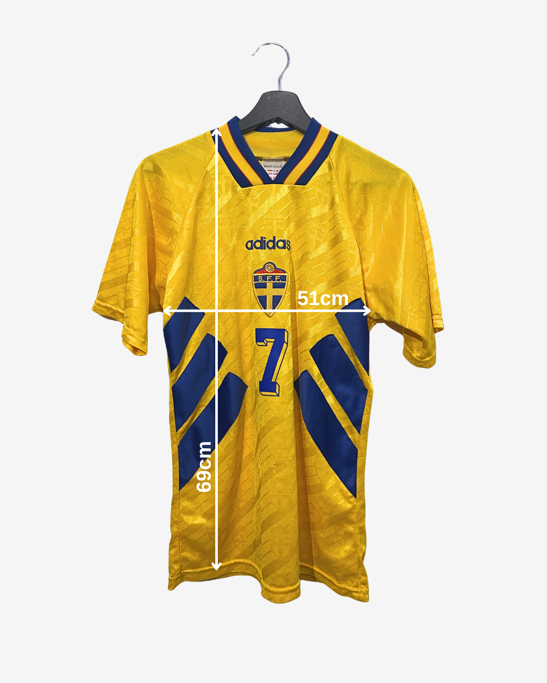 Yellow sports jersey with blue accents on a hanger, featuring Adidas logo and number 7.