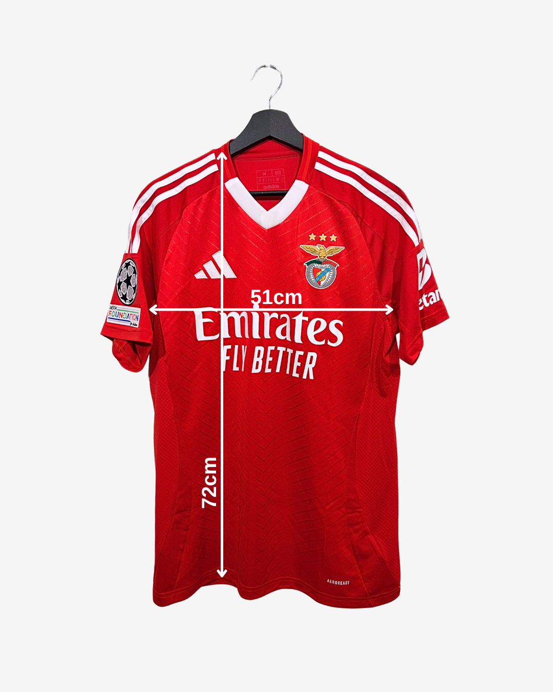Red sports jersey with white accents on a hanger, featuring Emirates branding.