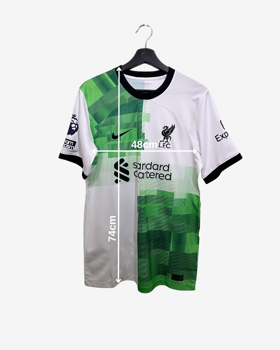 Green and white sports jersey with measurements on a hanger