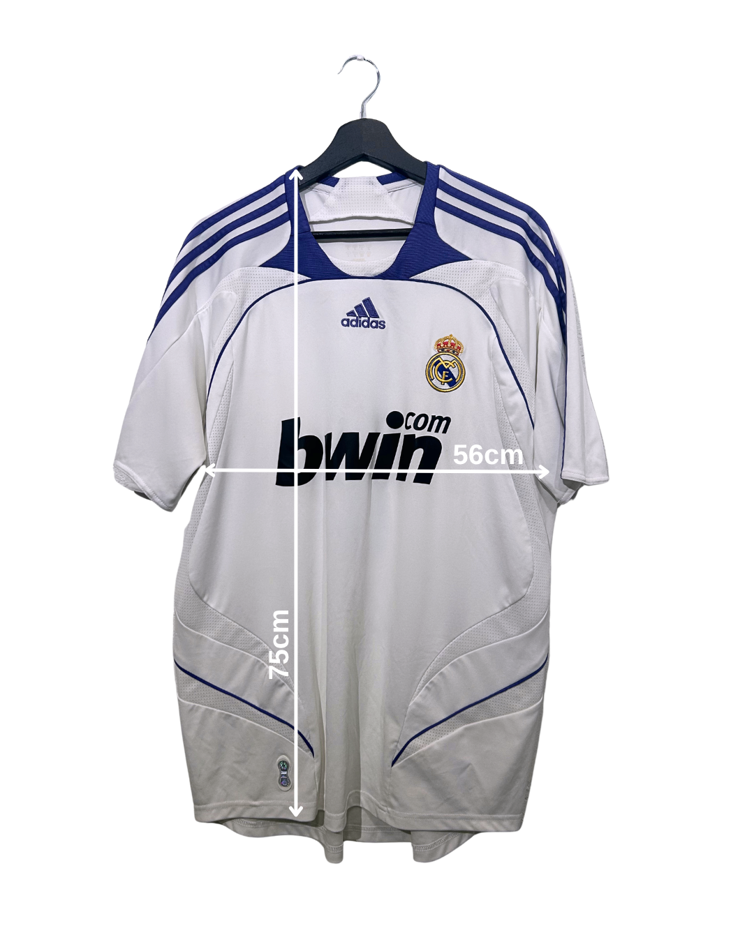 White sports jersey with blue accents on a hanger, featuring Adidas and Real Madrid logos.