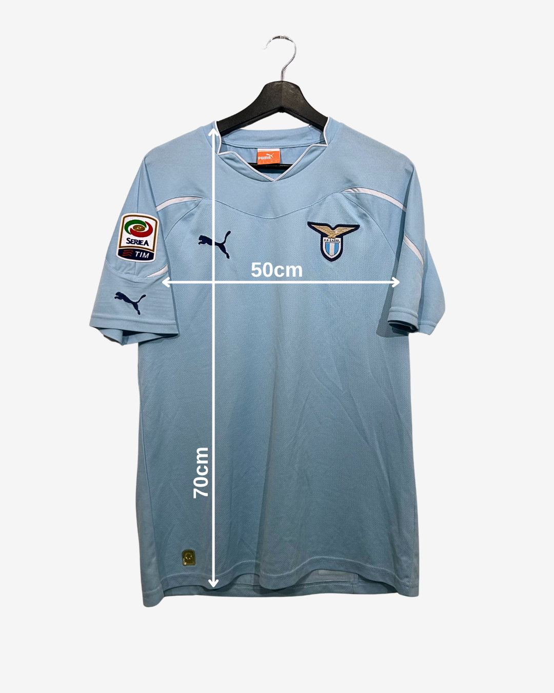 Light blue sports jersey with brand logos on a hanger, showing measurements.