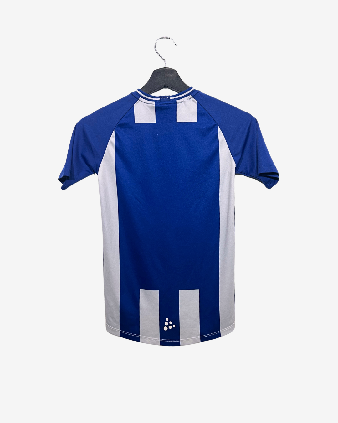 Blue and white sports jersey on a hanger against a white background