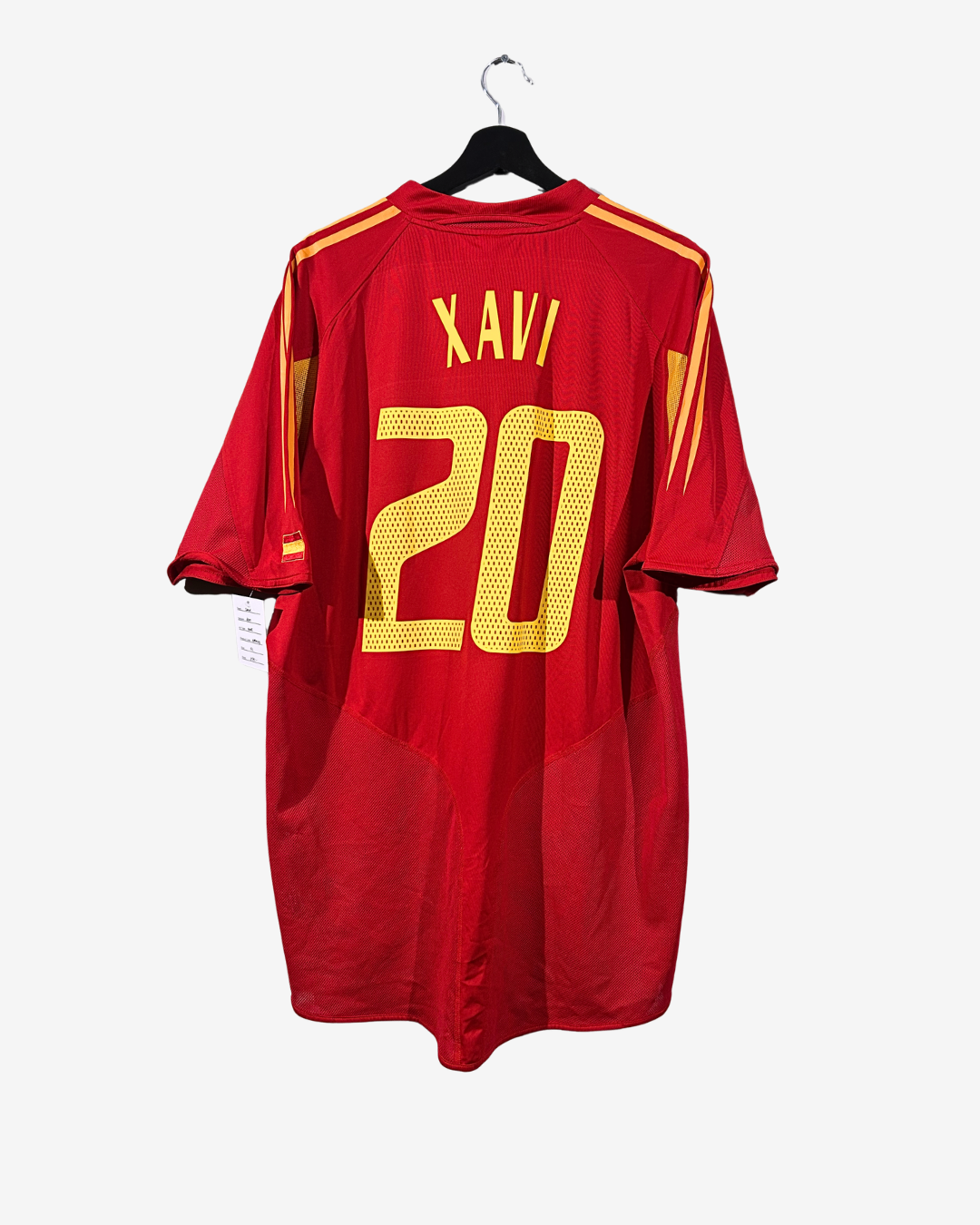 Red sports jersey with yellow numbering and lettering on a hanger against a white background