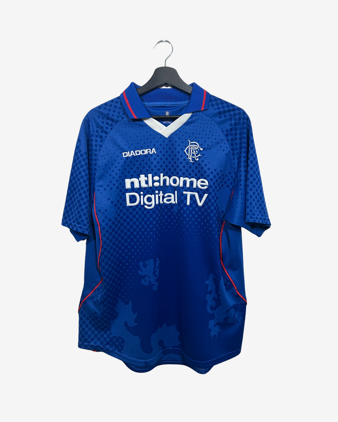 A blue short-sleeve soccer jersey hanging on a black hanger against a light gray background. The jersey features the Diadora logo on the right chest, the Rangers club crest on the left chest, and 'ntshome Digital TV' printed across the center front.