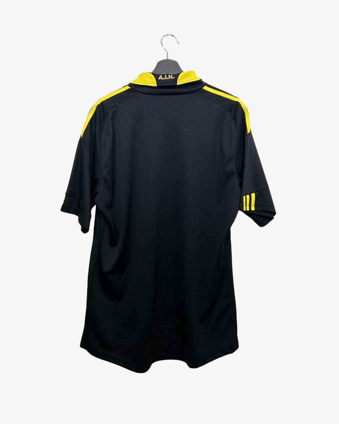 Black sports jersey with yellow accents on a hanger against a white background