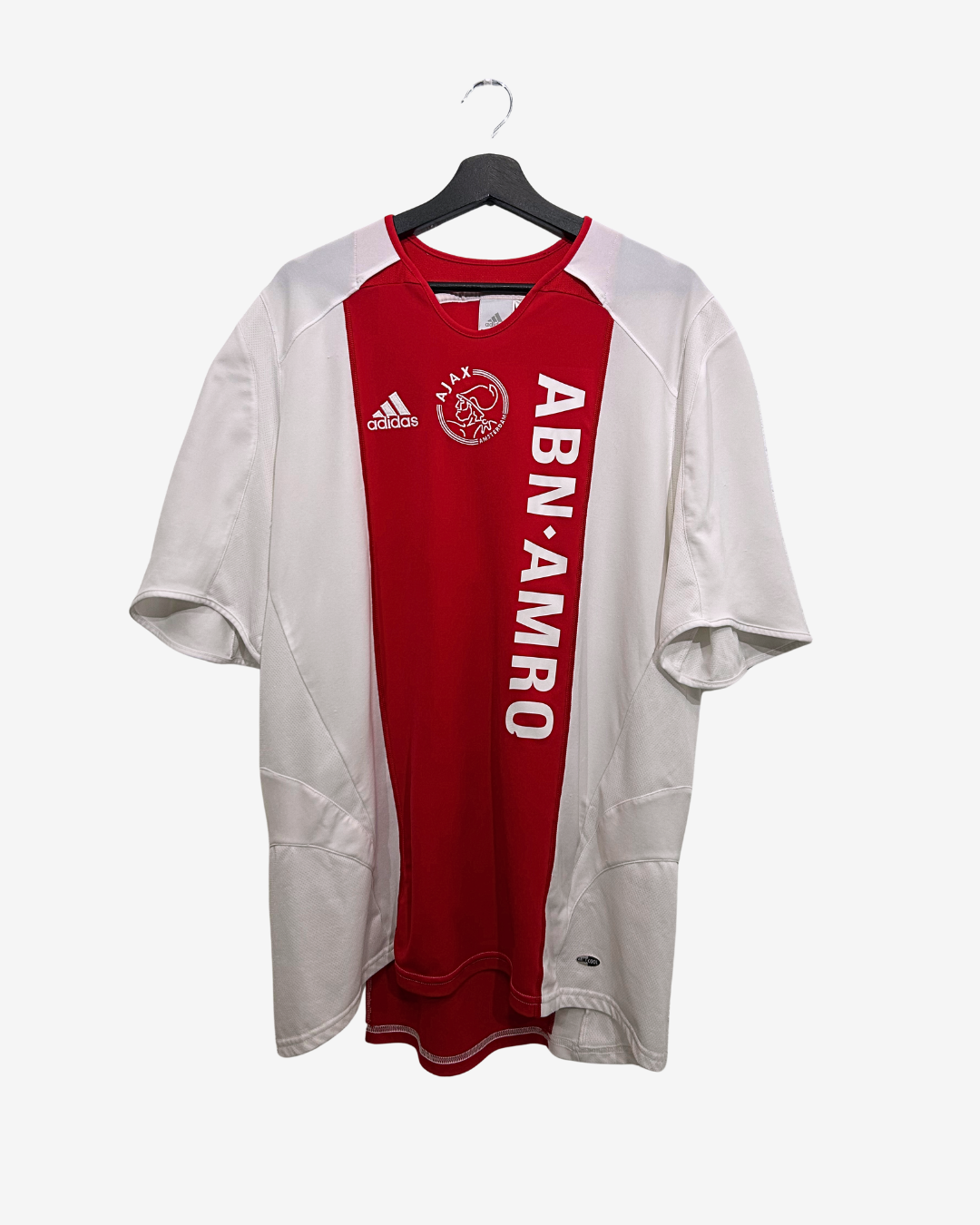 White and red sports jersey with Adidas logo on a hanger against a white background