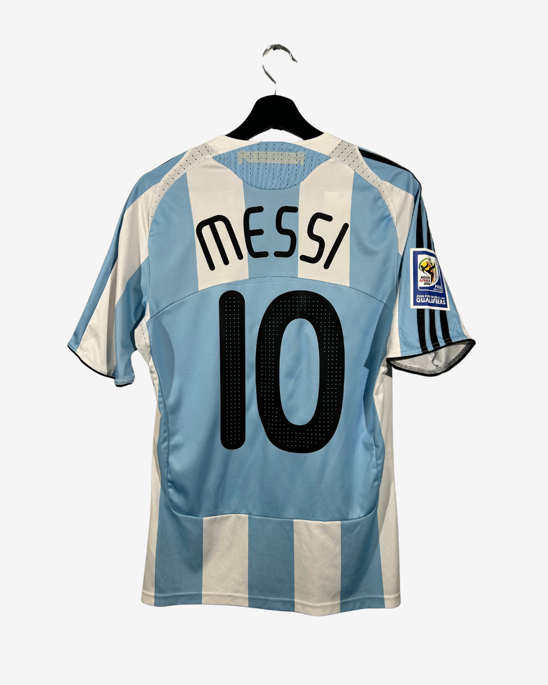 Light blue and white striped soccer jersey with 'Messi' and number '10' on a hanger against a white background