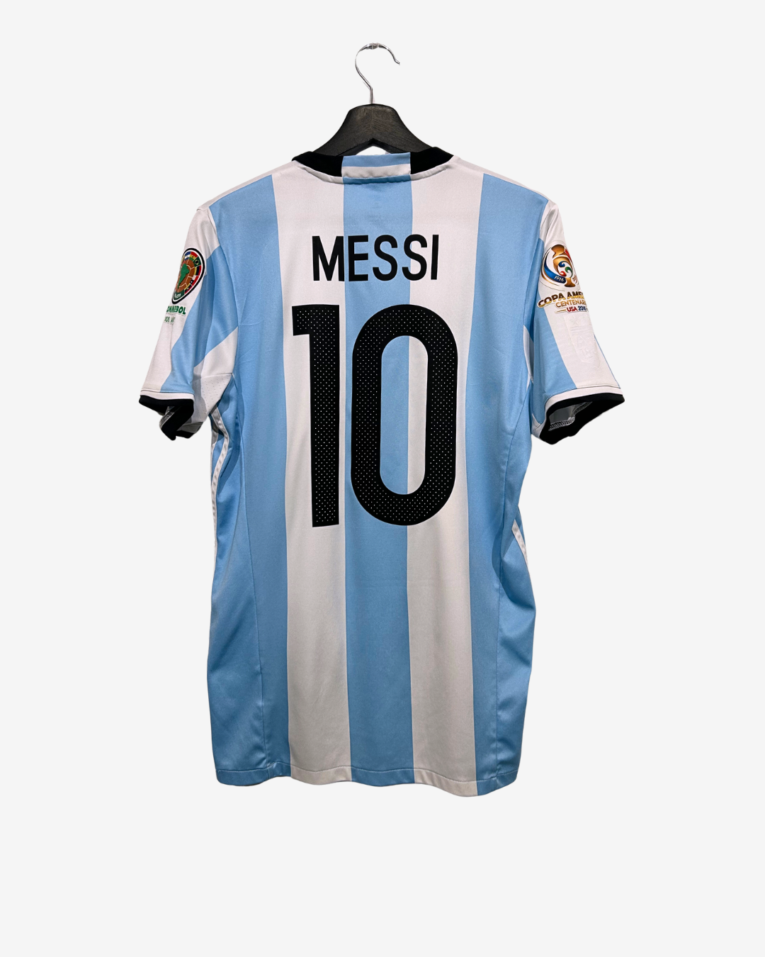 Soccer jersey with 'Messi' and number '10' on a hanger against a white background