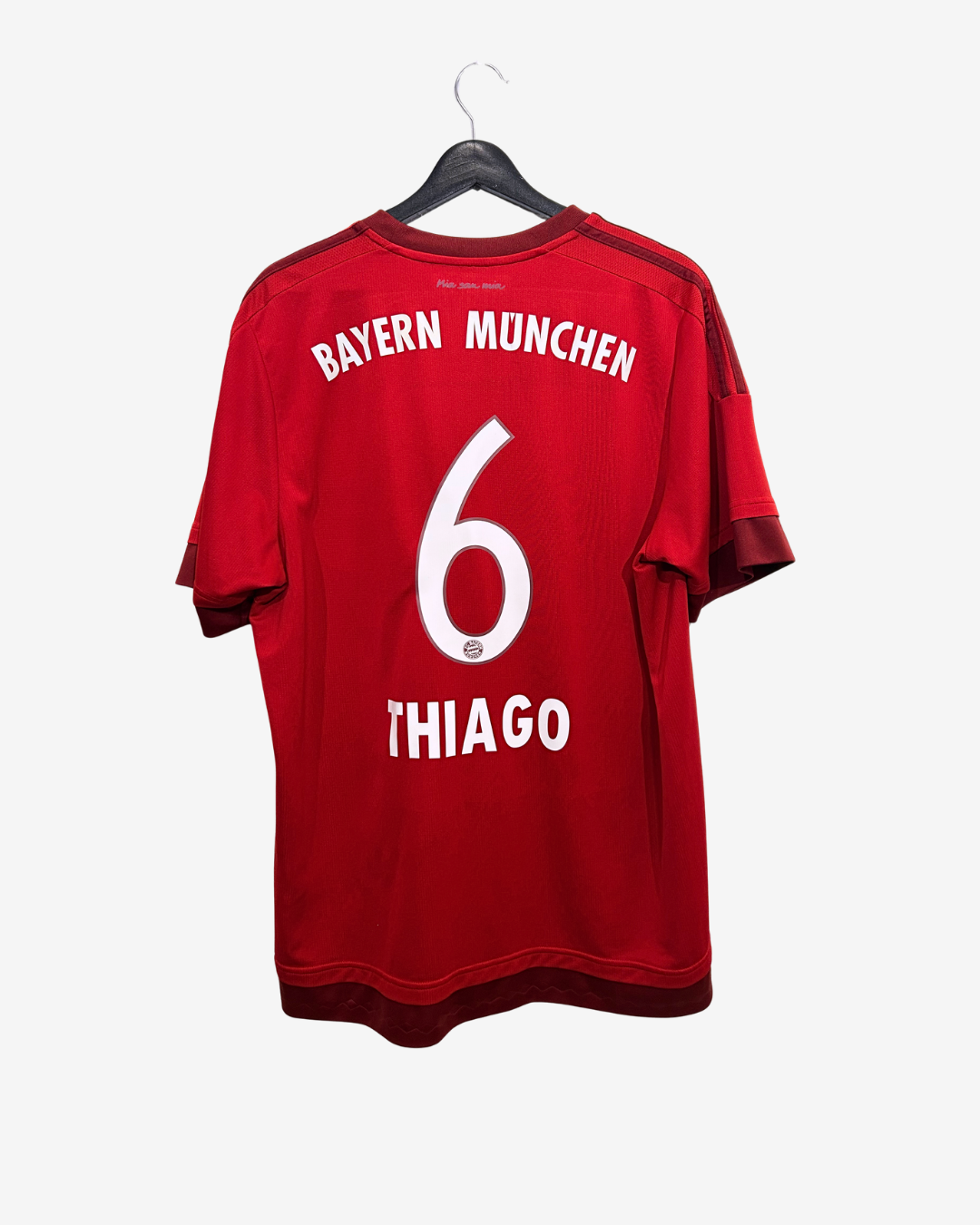 Red Bayern Munich jersey with number 6 and name 'THIAGO' on a hanger against a white background
