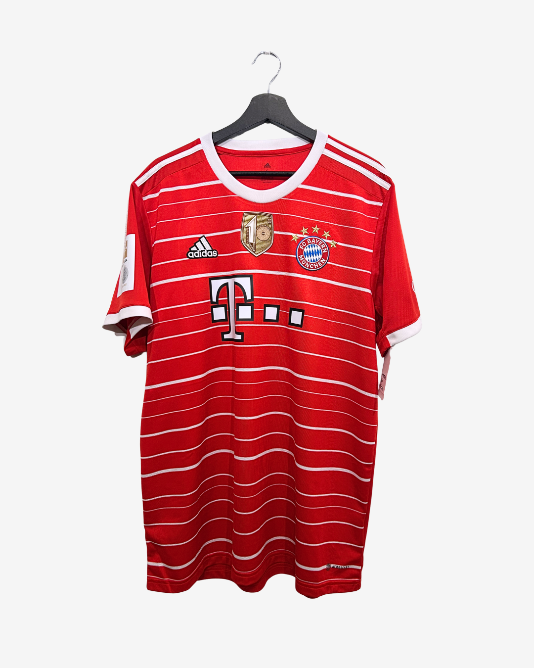 Red sports jersey with white stripes on a hanger against a white background