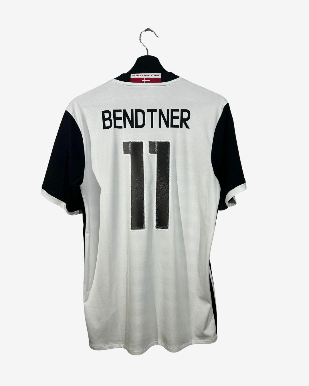 White sports jersey with black sleeves and 'Bendtner 11' printed on a white background