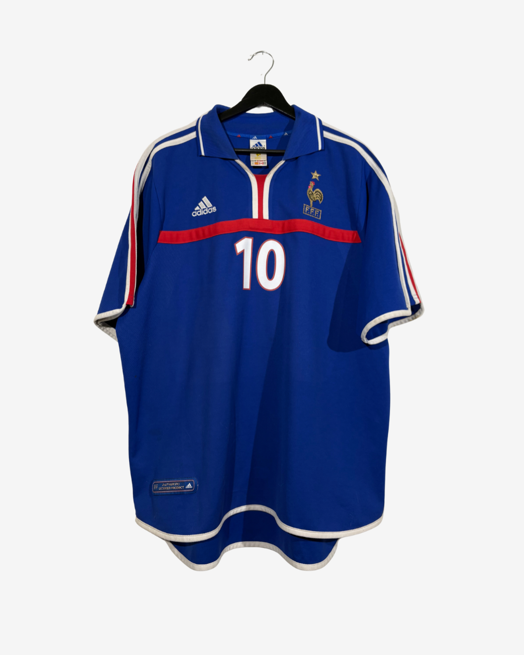 A vintage blue France national football team jersey with the number 10, featuring white and red accents, hanging on a black hanger against a light gray background.