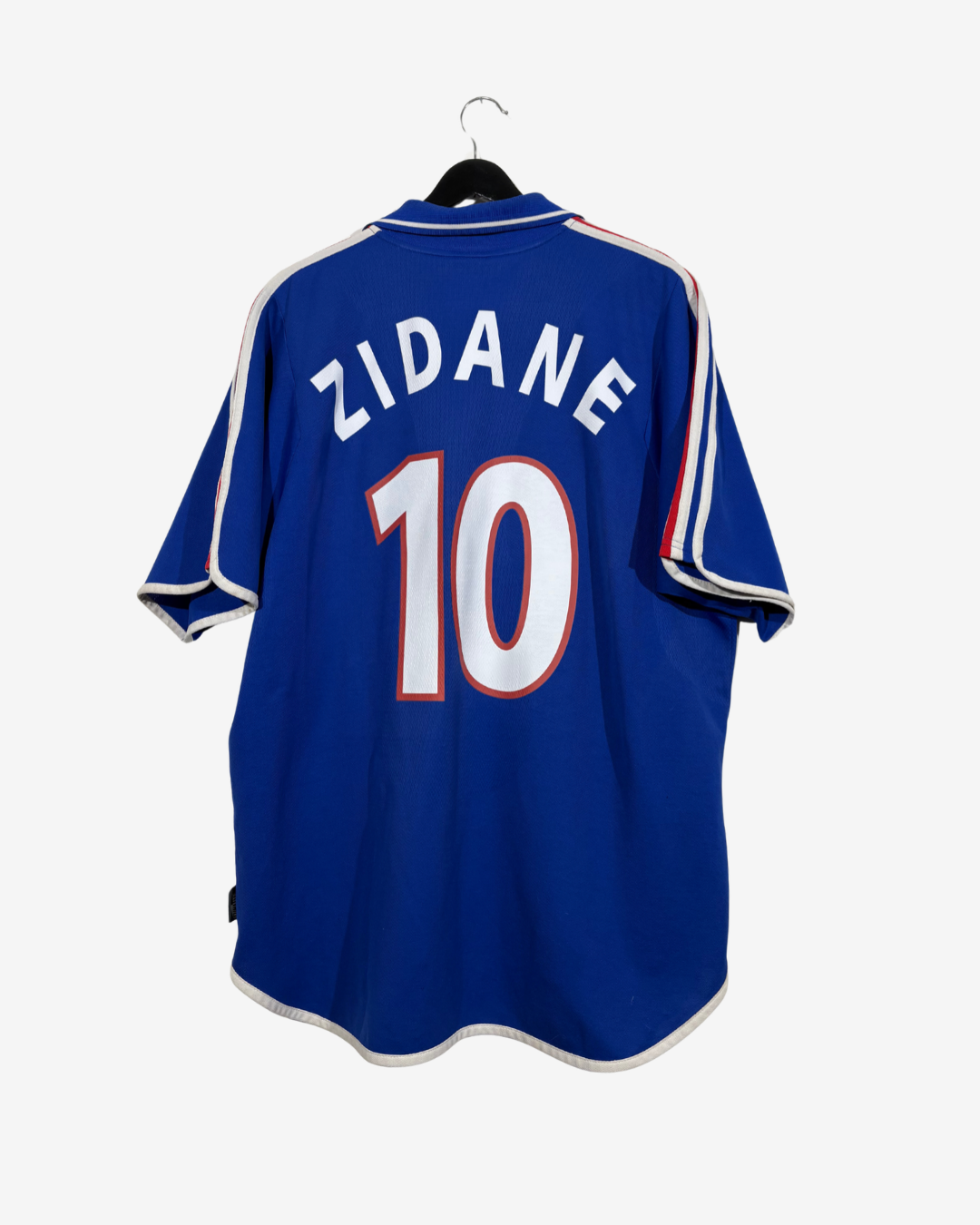 A royal blue soccer jersey with 'ZIDANE' and the number '10' printed on the back, hanging on a black hanger against a light gray background.
