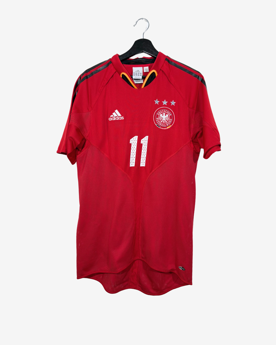 A red Adidas Germany soccer jersey with the number 11, hanging on a black hanger against a light gray background.