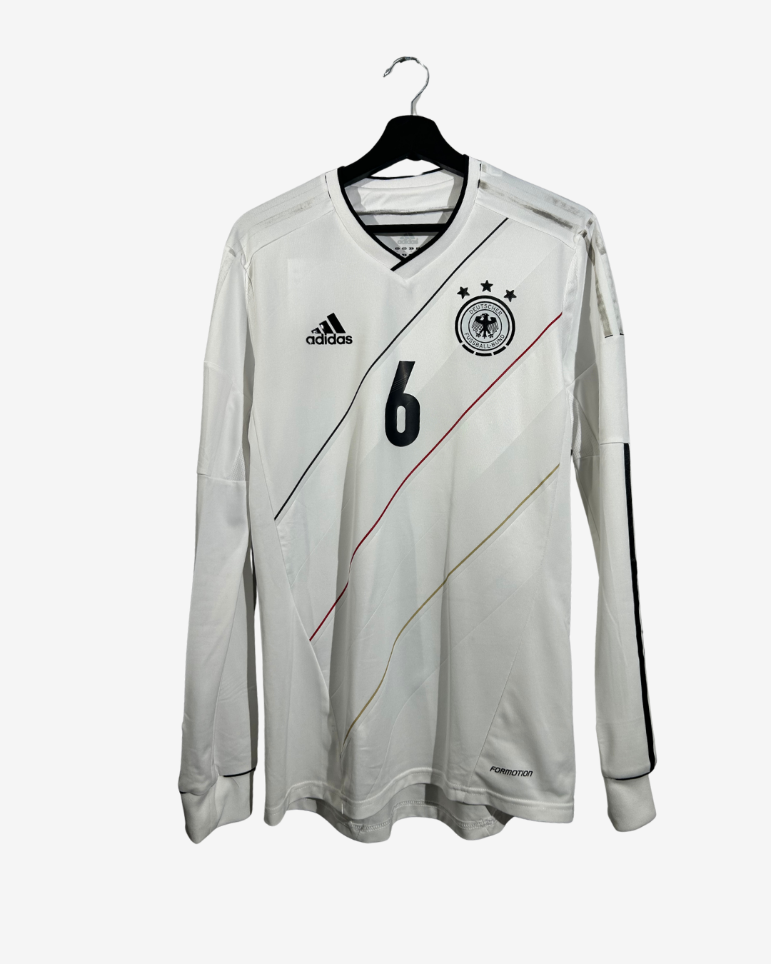 A white long-sleeve Germany national team soccer jersey with the number 6 on the chest, featuring the Adidas logo and DFB crest, hanging on a black hanger against a light gray background.