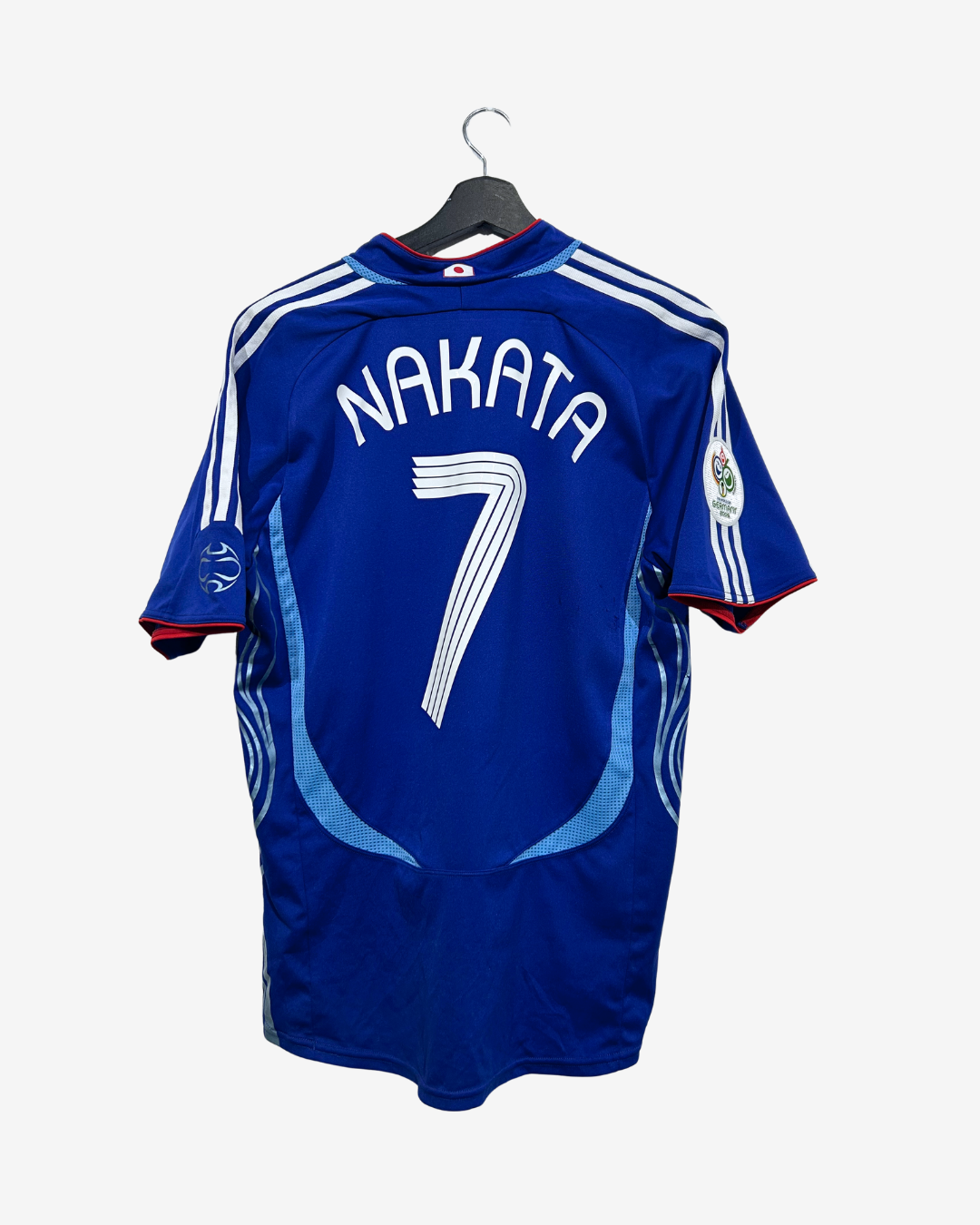 A blue FC Copenhagen soccer jersey with 'NAKATA' and the number '7' printed on the back, hanging on a black hanger against a light gray background.