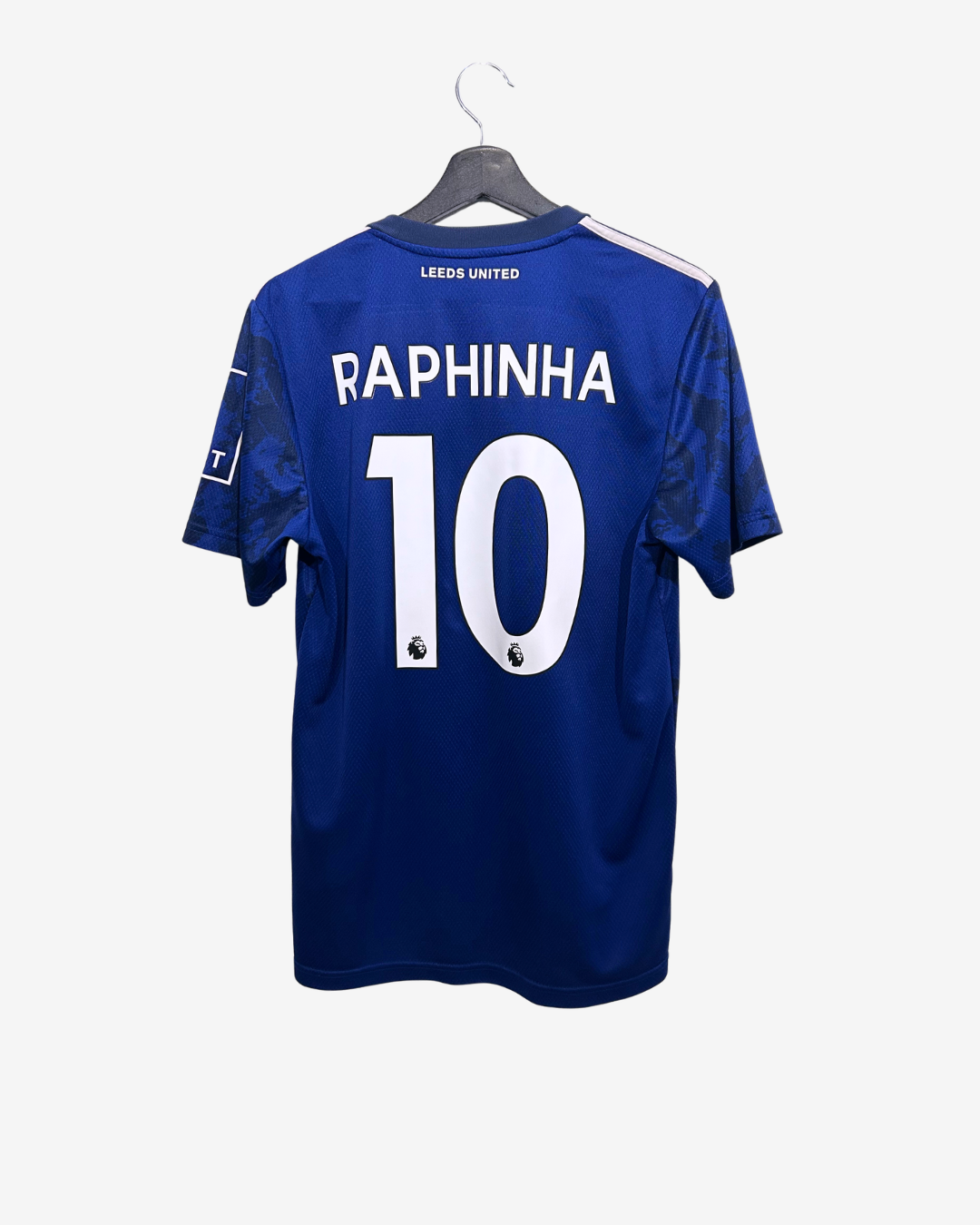 Blue sports jersey with 'Raphinha 10' on a hanger against a white background