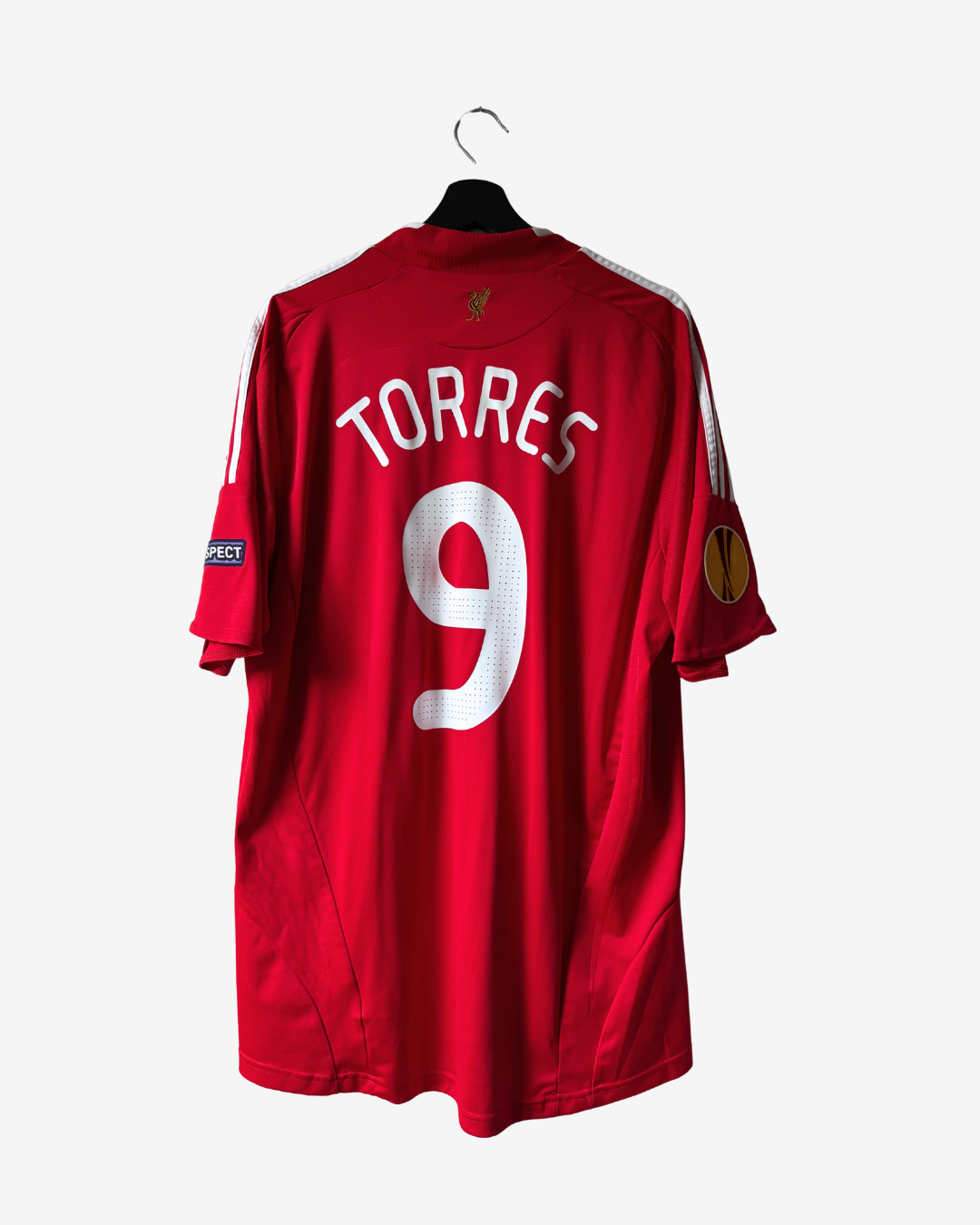 A red short-sleeve sports jersey hanging on a black hanger against a light gray background. The back of the jersey features the name 'TORRES' and the number '9' in white, with white shoulder stripes and a UEFA Champions League patch on the sleeve.