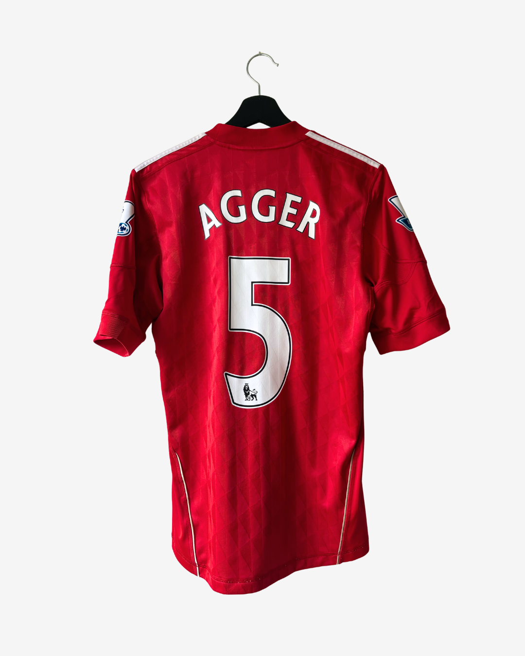 A red short-sleeve football jersey hanging on a black hanger against a light gray background. The back of the shirt shows the name 'AGGER' and the number '5' in white with a black outline.