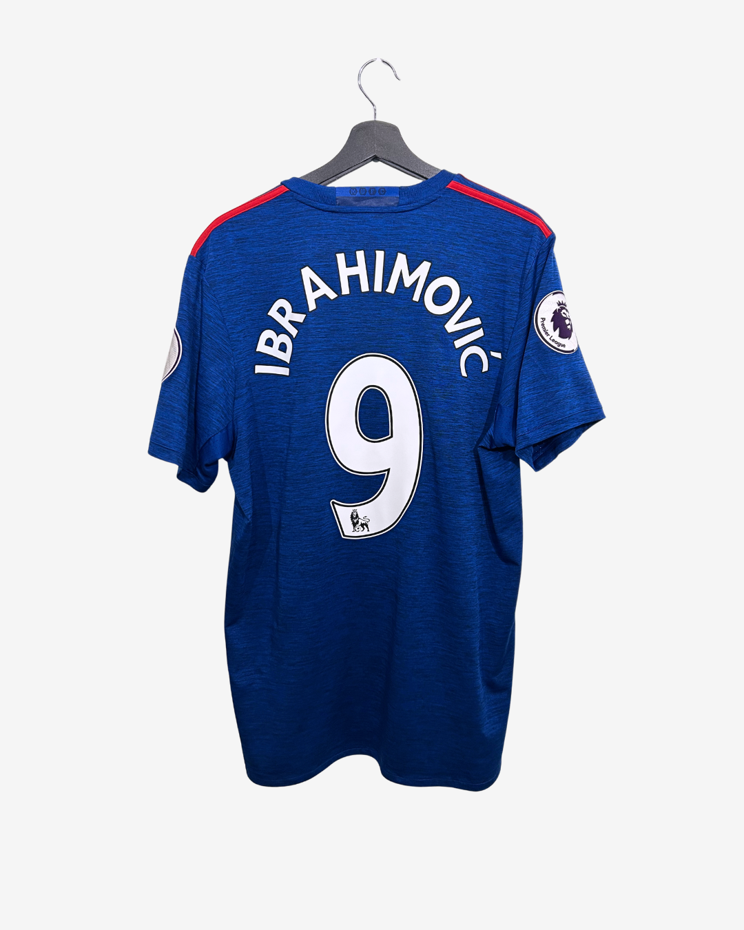 Blue sports jersey with 'Ibrahimovic' and number '9' on a hanger against a white background