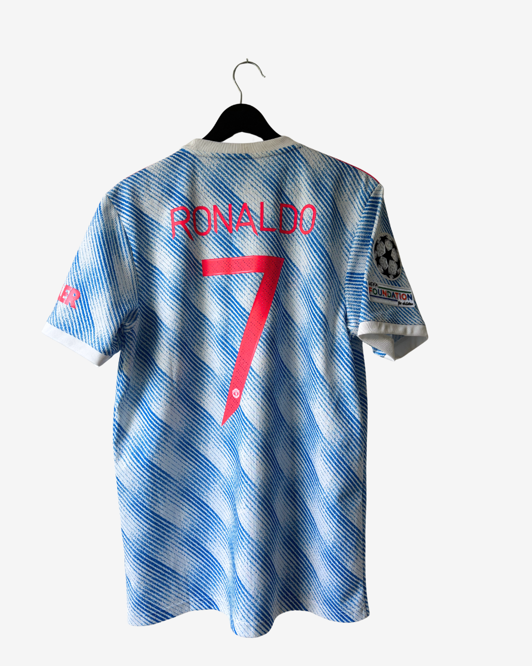 A blue and white patterned soccer jersey with 'RONALDO' and the number 7 printed in red on the back, hanging on a black hanger against a light gray background.