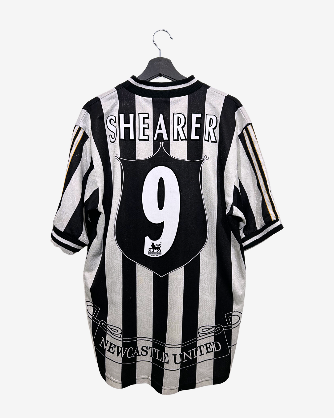 Black and white striped sports jersey with 'Shearer 9' on a hanger