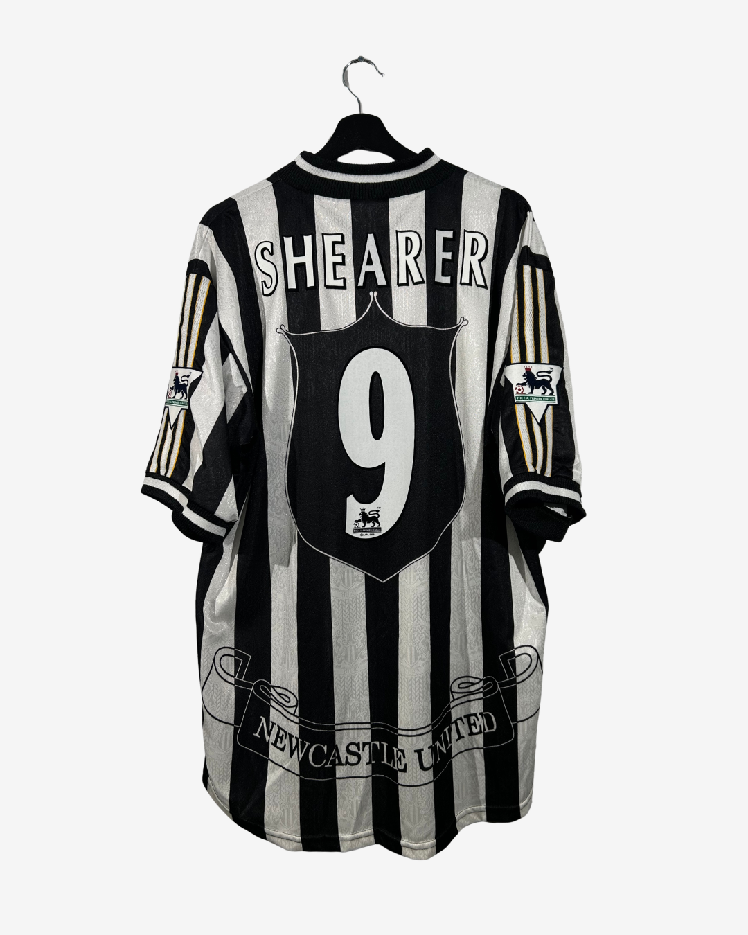 Black and white striped sports jersey with 'Shearer 9' on a hanger