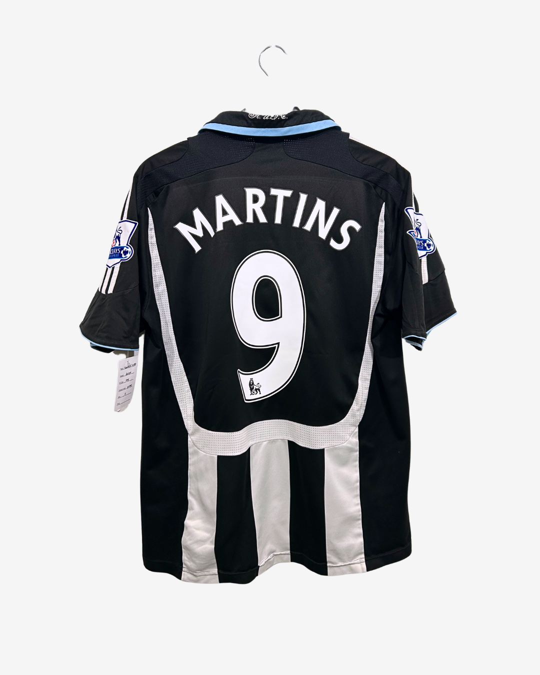 Black and white sports jersey with 'Martins' and number '9' on a hanger against a white background