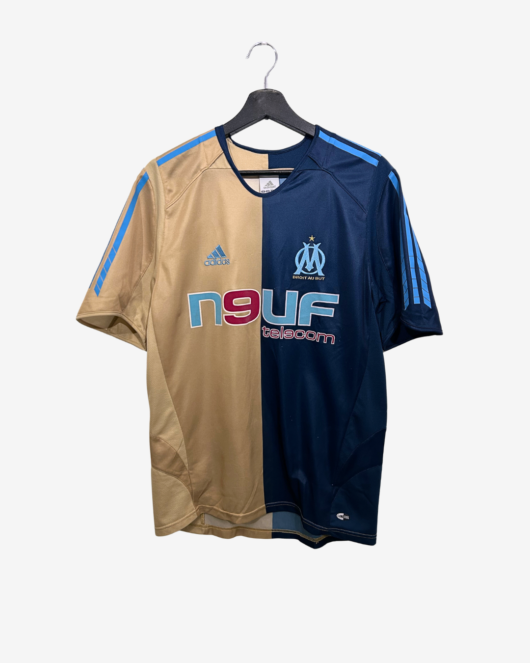 Two sports jerseys, one beige and one navy, on a hanger with visible branding.