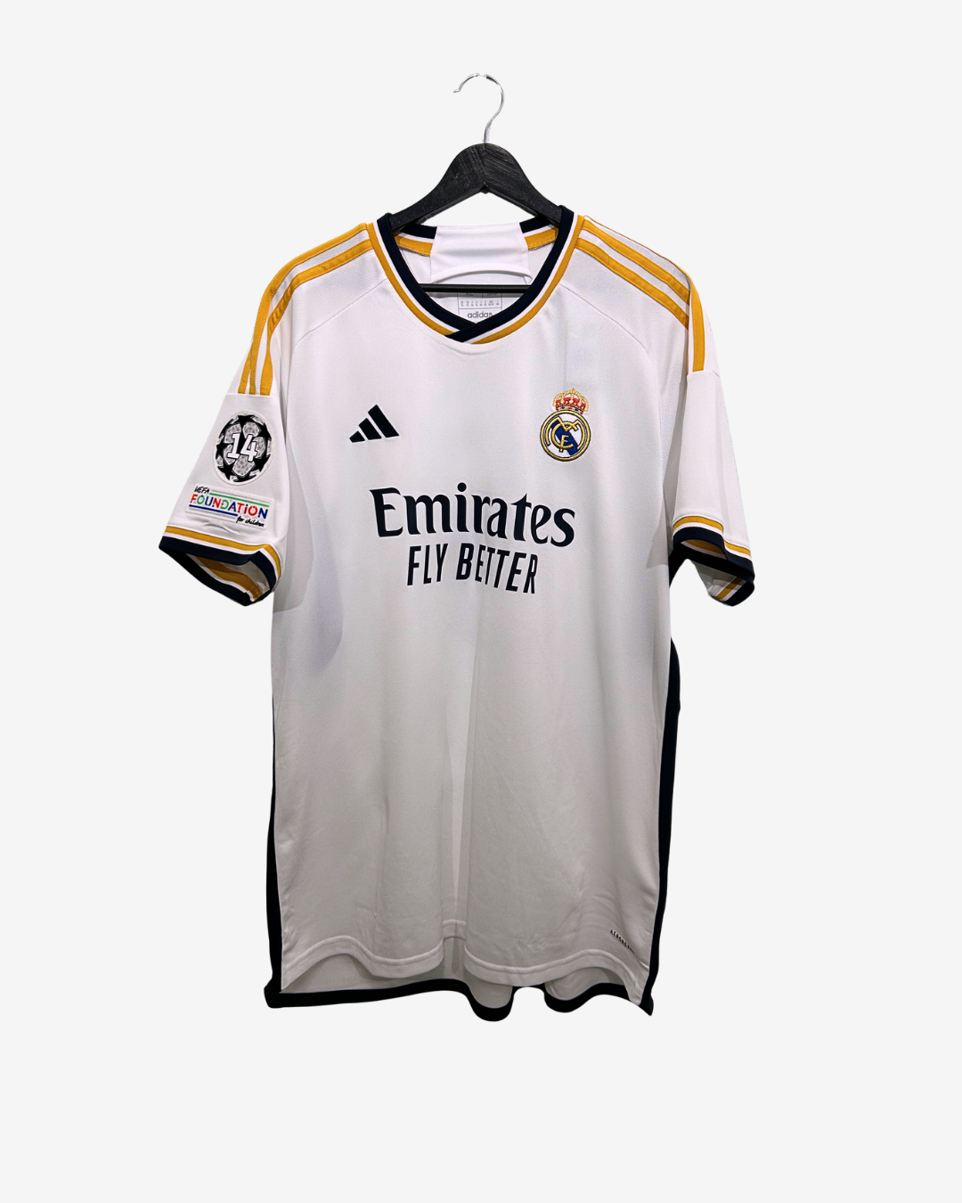 White sports jersey with gold accents on a hanger against a white background