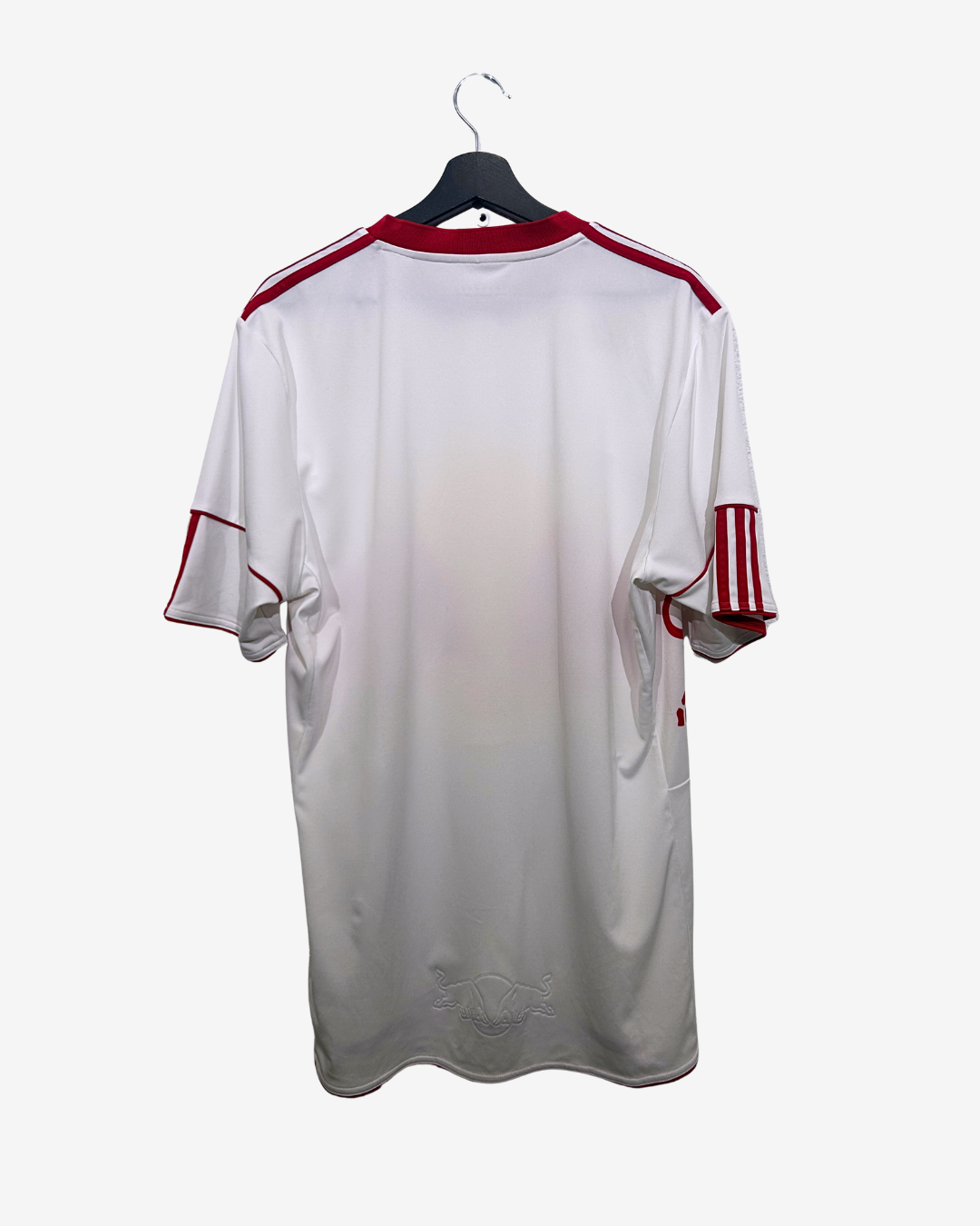 White sports jersey with red accents on a hanger against a white background
