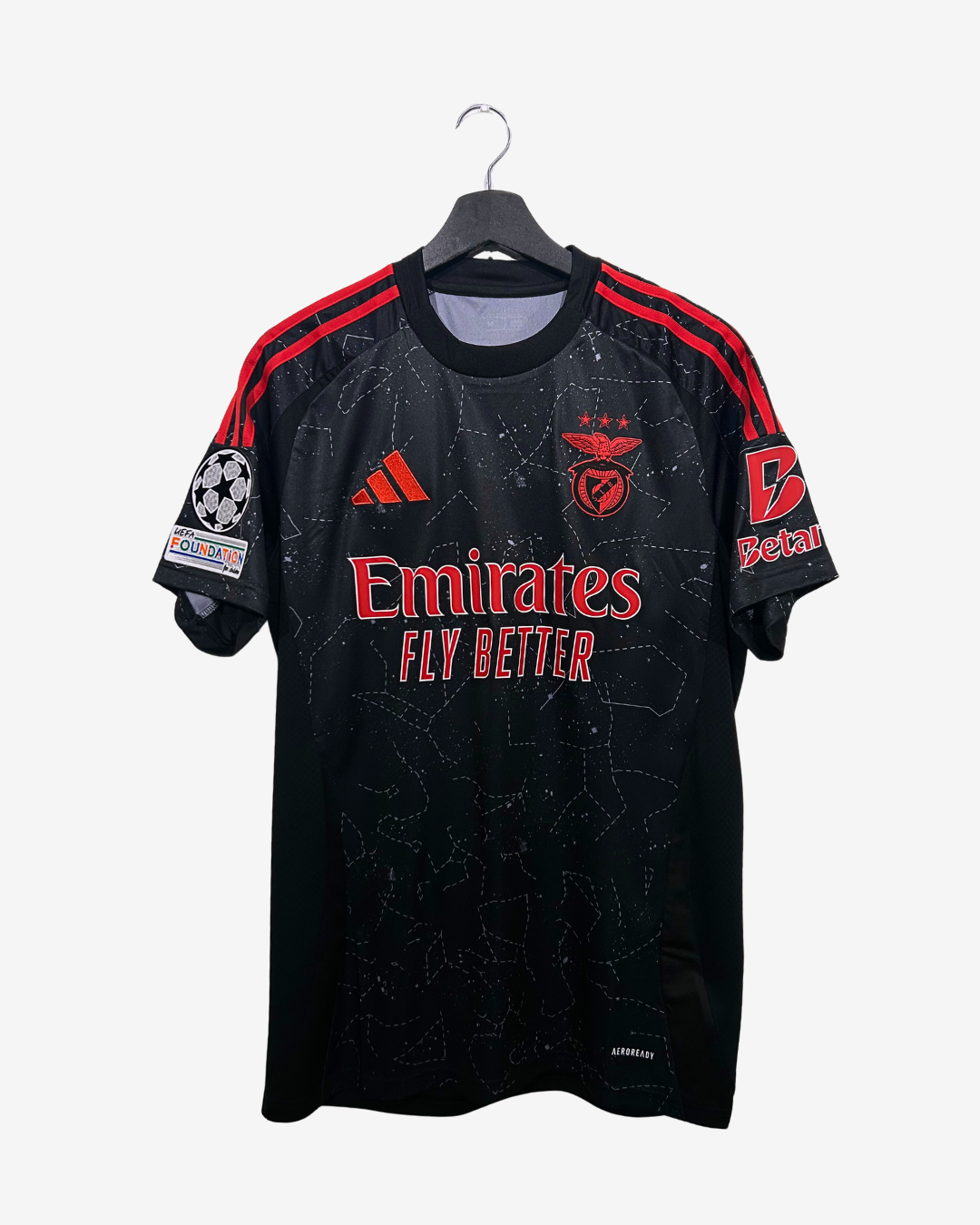 Black sports jersey with red accents on a hanger against a white background