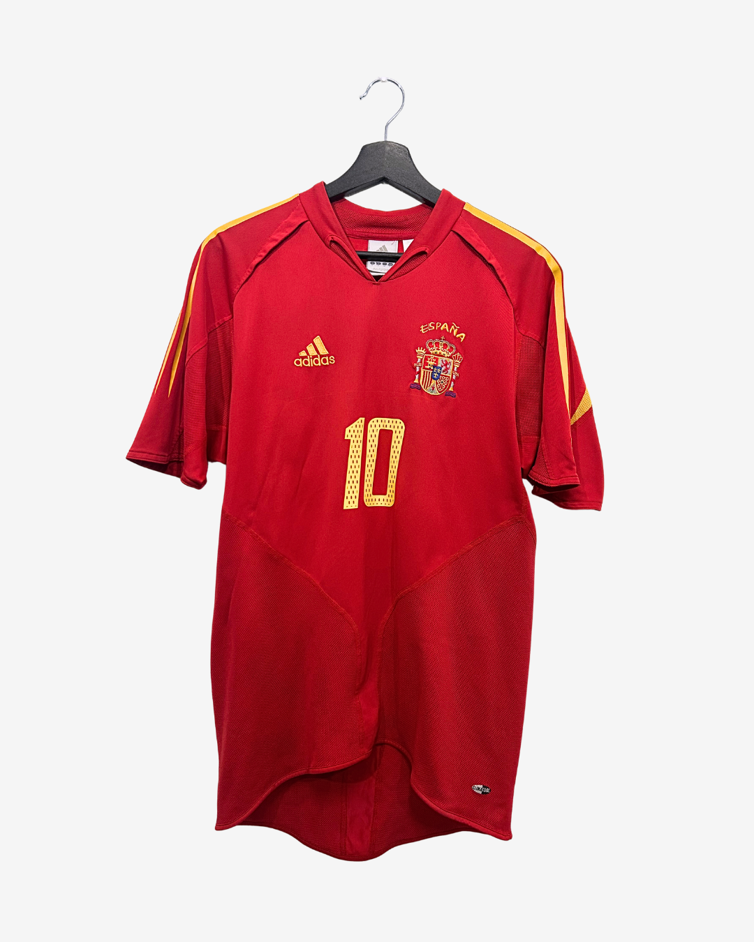 Red soccer jersey with gold accents and number 10, hanging on a white background
