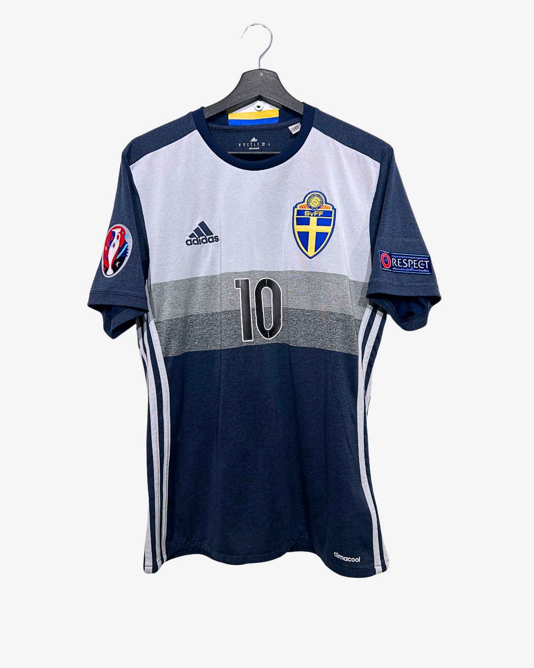 Navy and white sports jersey with number 10 on a hanger against a white background