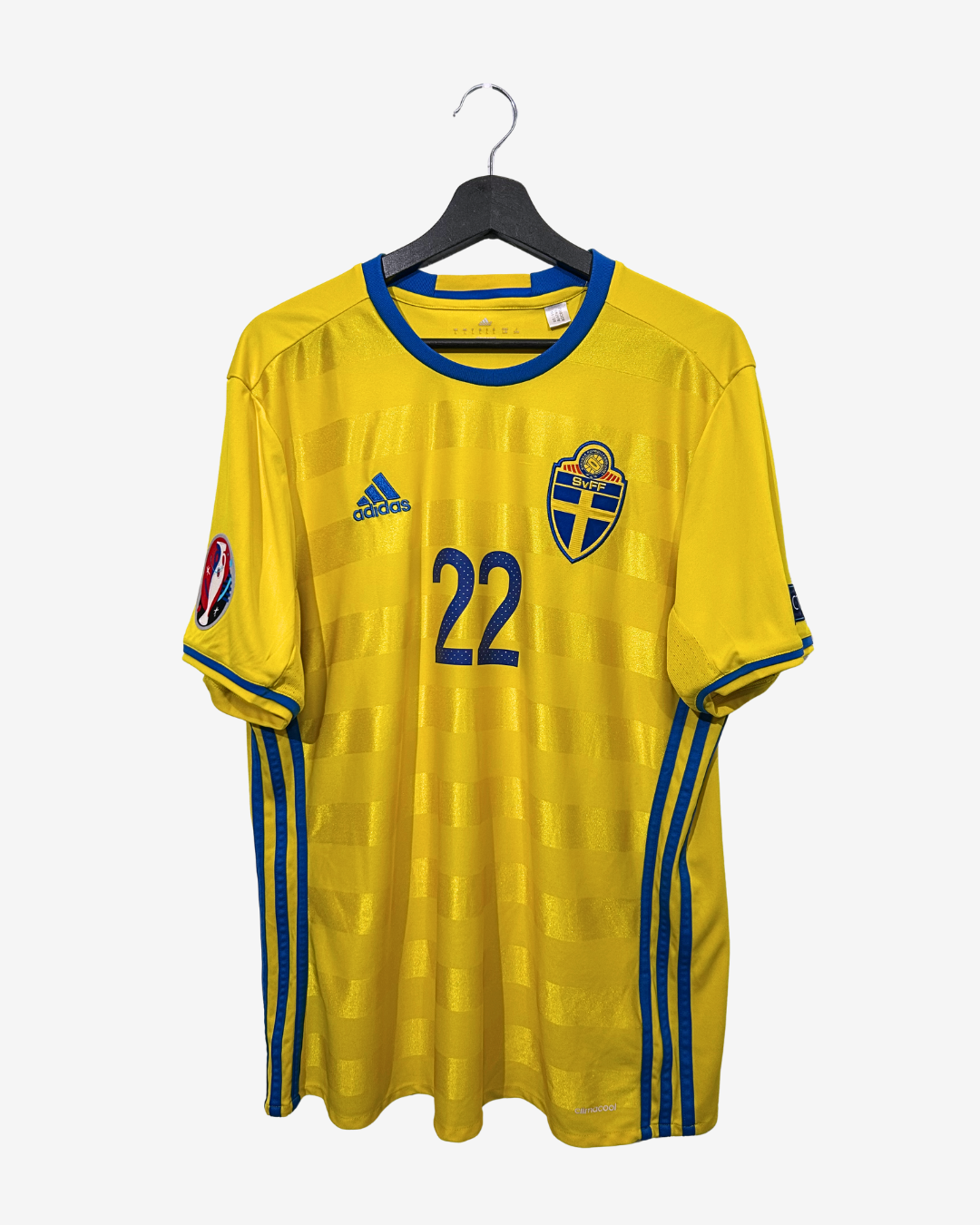 Yellow sports jersey with blue accents and number 22 on a hanger against a white background