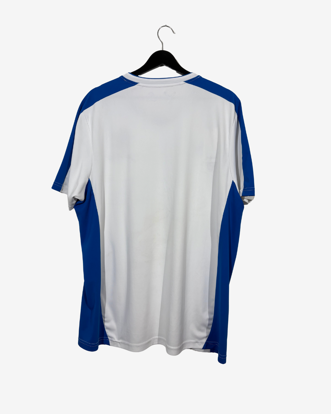 A short-sleeve athletic t-shirt with a white body and royal blue raglan sleeves, hanging on a black hanger against a light gray background.