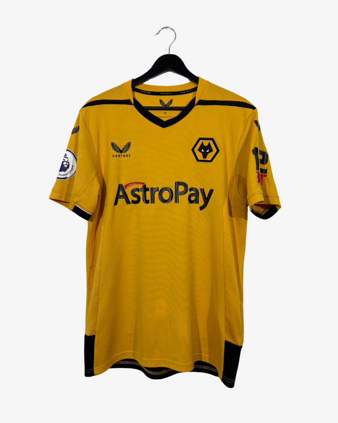 A yellow and black Wolverhampton Wanderers football jersey hanging on a black hanger against a light gray background. The jersey features the 'AstroPay' sponsor logo across the chest, the club's wolf crest, and the VFL logo.