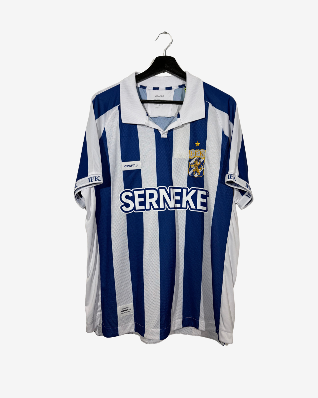 A IFK Göteborg football jersey with blue and white vertical stripes, featuring the 'SERNEKE' sponsor logo on the chest, hanging on a black hanger against a light gray background.