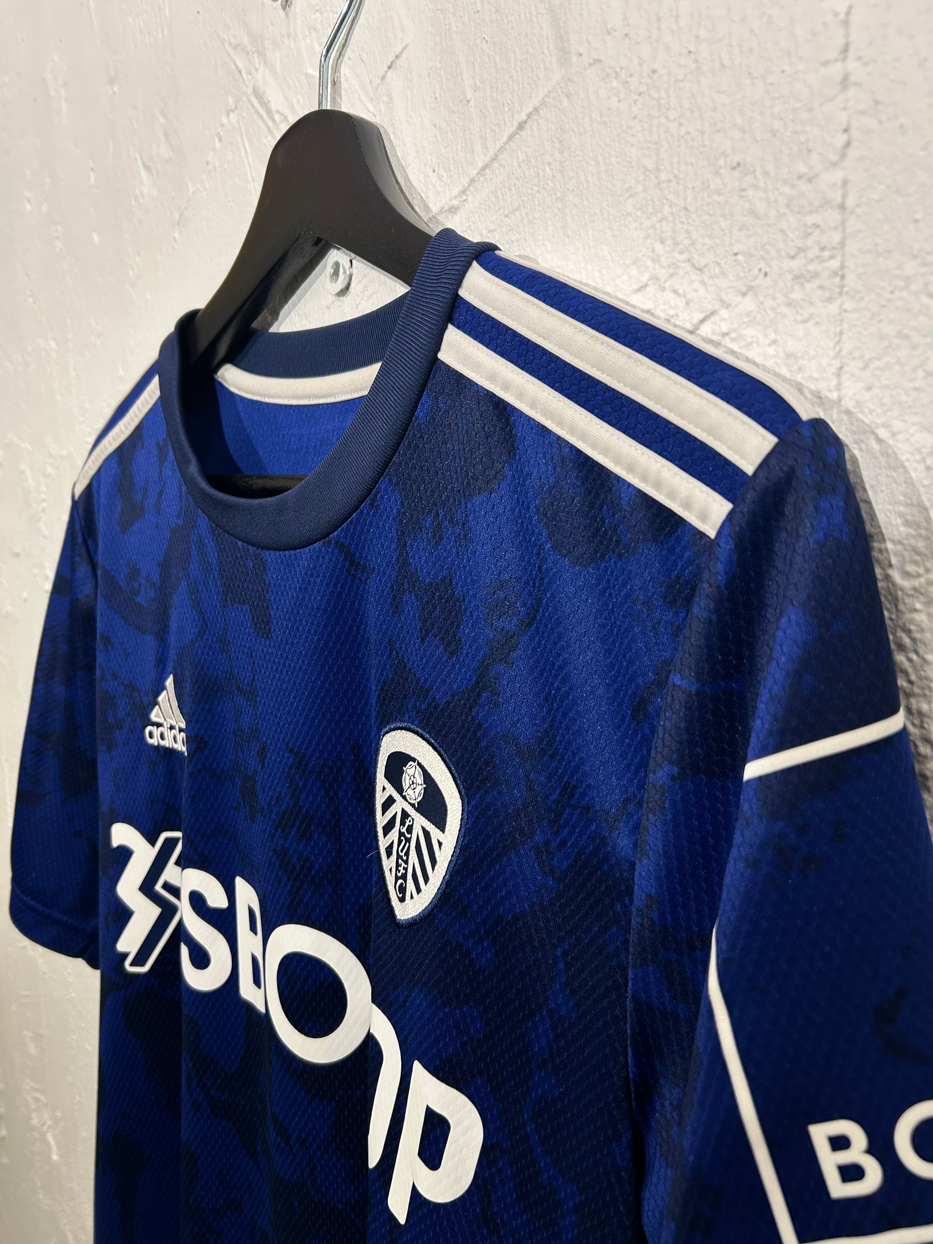 Blue sports jersey with branding on a light gray background