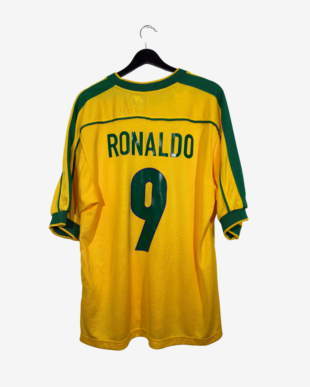 A yellow and green Brazil soccer jersey with 'RONALDO' and the number '9' printed on the back, hanging on a black hanger against a light gray background.