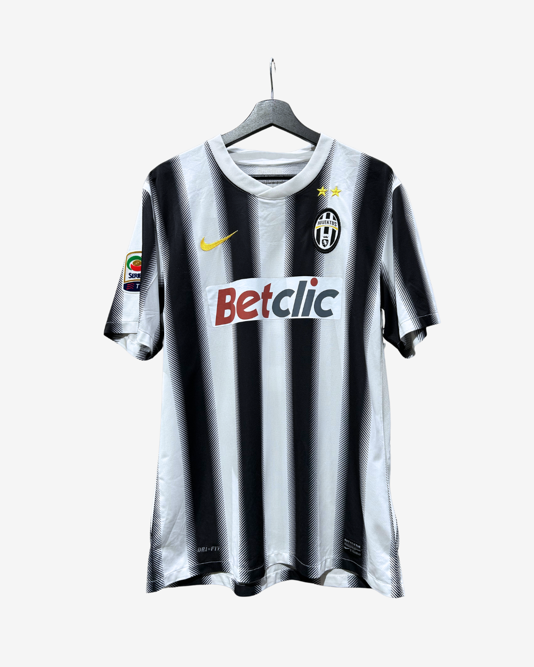 A black and white vertically striped Juventus soccer jersey hanging on a hanger against a light gray background. The jersey features the yellow Nike swoosh on the right chest, the Juventus club crest on the left chest, and the Betclic sponsor logo across the center.