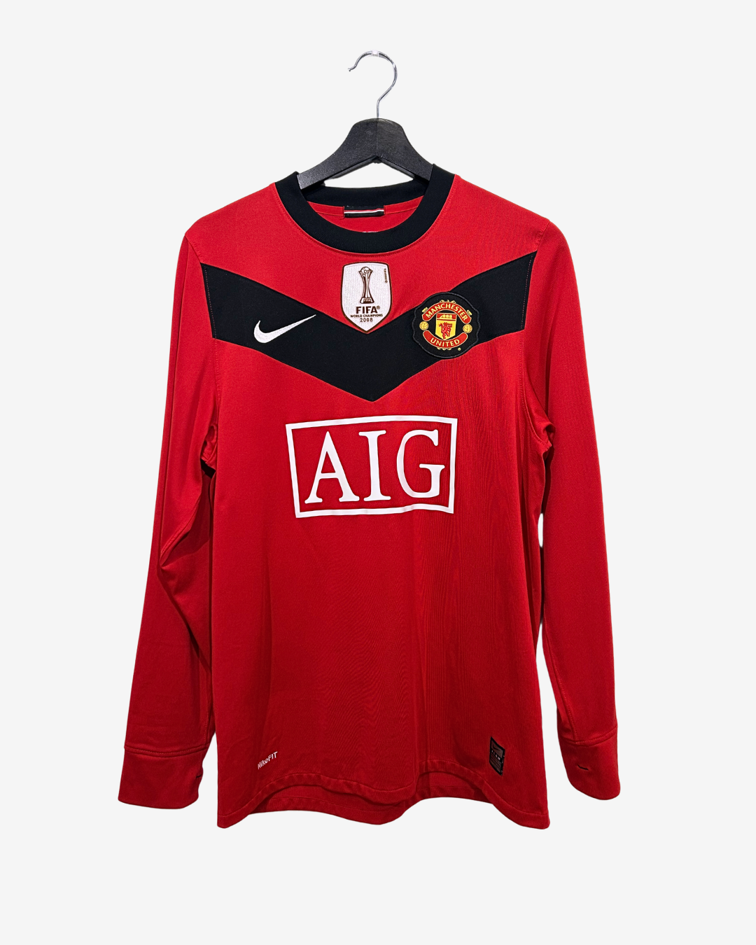 Red sports jersey with visible branding on a hanger against a white background