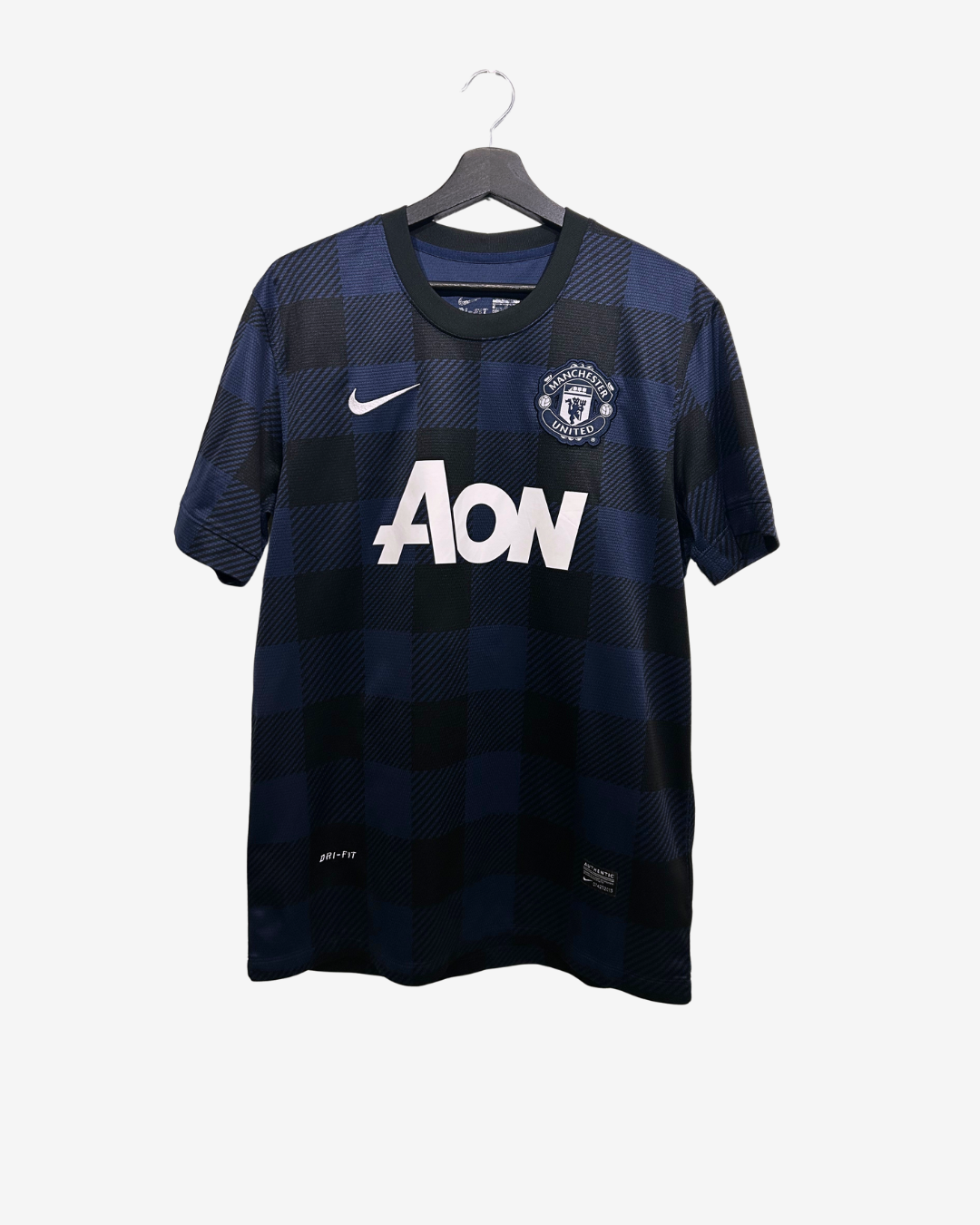 Man United jersey with Nike logo on a hanger against a white background