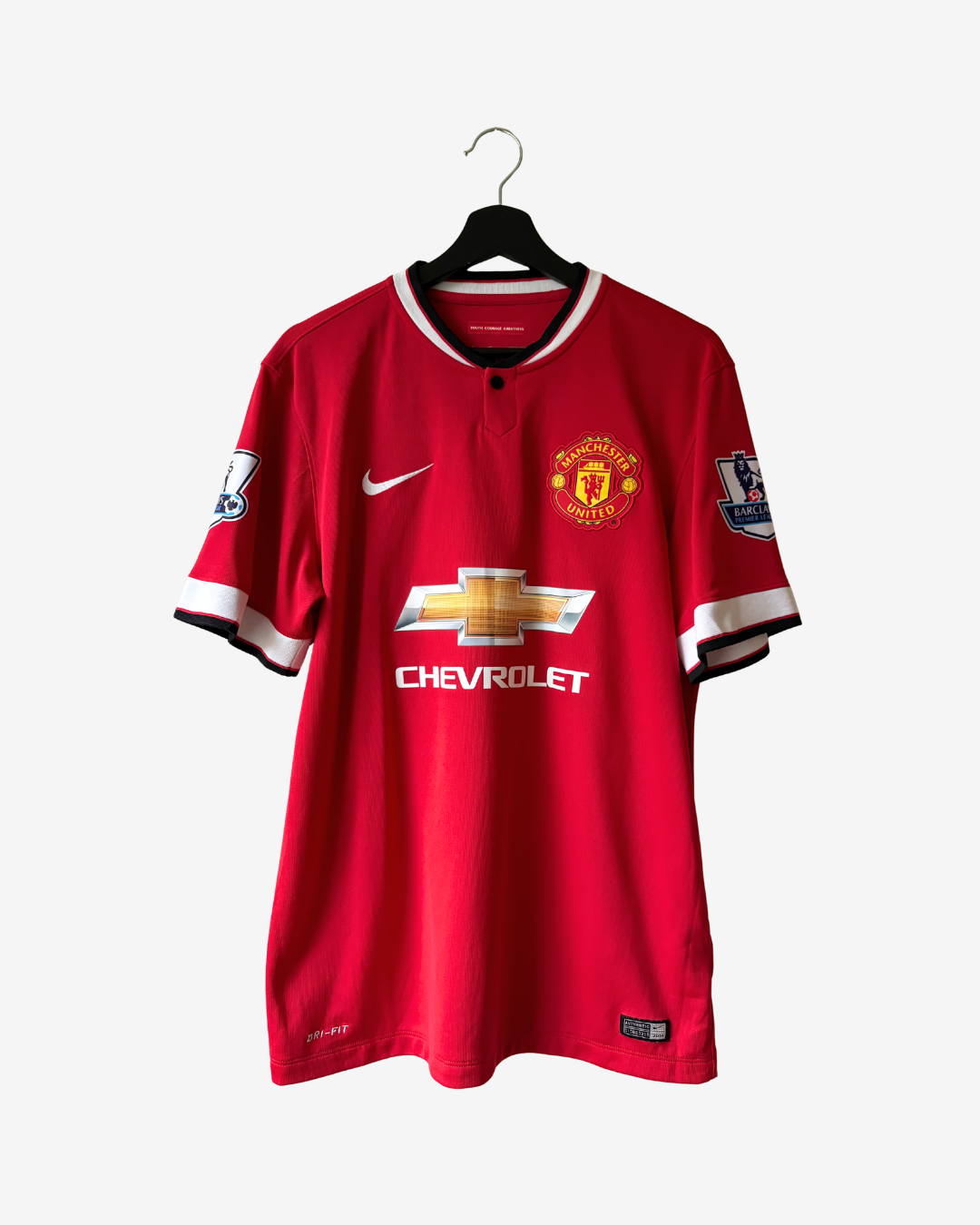 A red Manchester United soccer jersey by Nike, featuring the Chevrolet sponsor logo, displayed on a black hanger against a light gray background.
