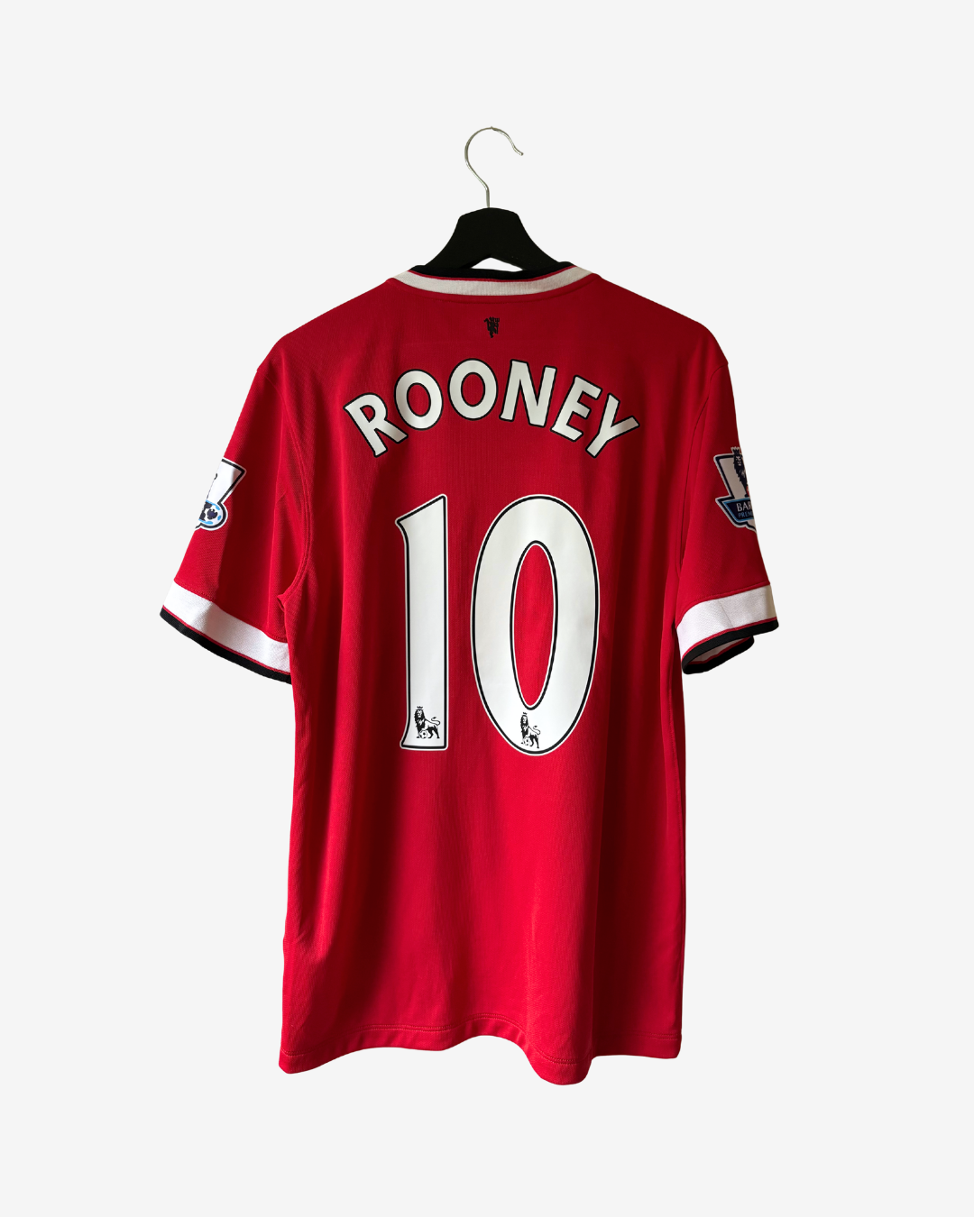 A red Manchester United long-sleeve soccer jersey with 'ROONEY' and the number '10' printed on the back, hanging on a black hanger against a light gray background.