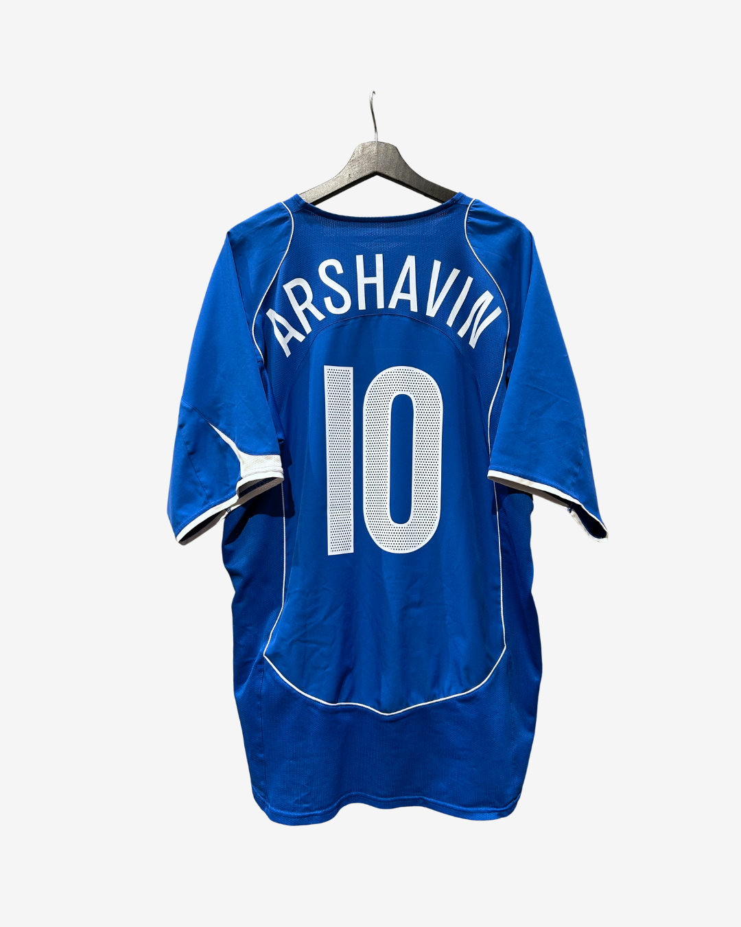 A royal blue short-sleeve sports jersey hanging on a wooden hanger against a light gray background. The back of the jersey features the name 'ARSHAVIN' in white arched lettering above the number '10' in white.