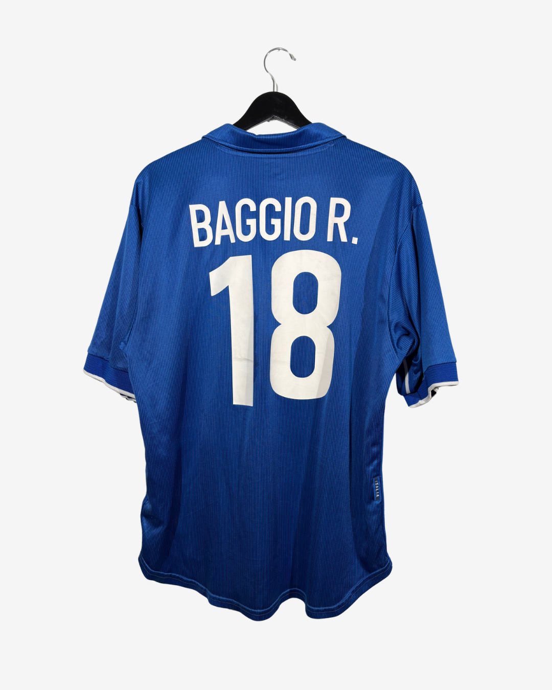 A blue soccer jersey hanging on a black hanger against a light gray background, showing the back with 'BAGGIO R.' and the number '18' in white.