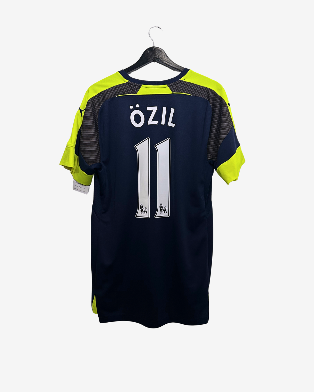 Soccer jersey with 'Ozil' and number '11' on a hanger against a white background