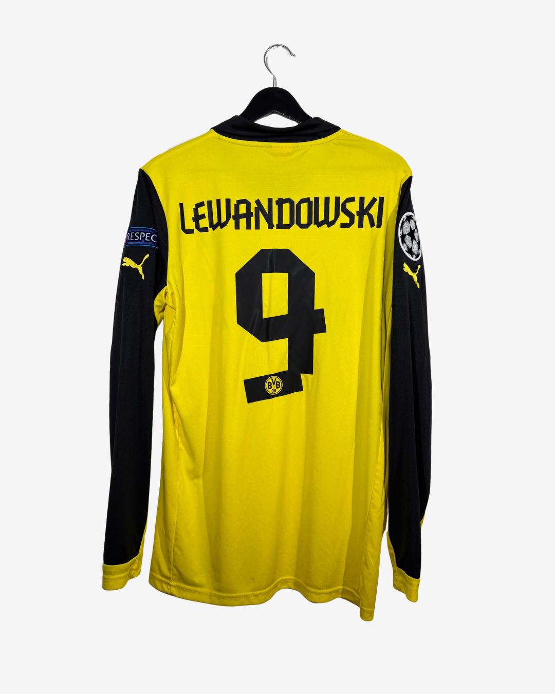 A yellow and black long-sleeve soccer jersey hanging on a black hanger against a light gray background. The back of the jersey features the name 'LEWANDOWSKI' and the number '9' in black, with a Puma logo on the right sleeve and a UEFA patch on the left sleeve.